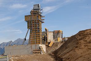Umbauarbeiten des Stöcklifts in der SkiWelt Söll, drei Arbeiter mit gelben Helmen installieren erste Betonteile