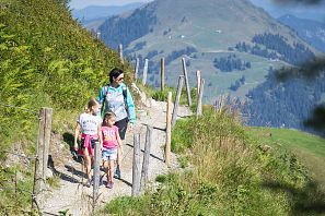 Mutter mit zwei Kindern beim wandern in der Natur.