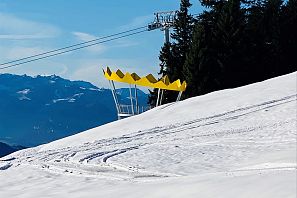 Gelbe Kronen-Skulptur auf der verschneiten Aussichtsplattform: Kaiserliche Wohlfühlplattform in der SkiWelt Scheffau, mit Blick auf die umliegenden Berge und Seilbahn