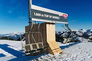Kennzeichnung und Aussichtspukt am höchsten Punkt im Skigebiet SkiWelt auf 1869m in Westendorf mit zwei ausgemusterten 4er Sesseln eines Sesselliftes als Sitzmöglichkeit