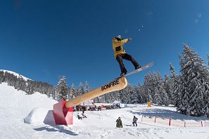 Ein Snowboarder macht einen Stunt in einem Funpark.