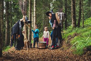 Kinder und Hexen spazieren durch den Wald.