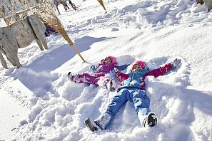 Kinder machen Schneeengel.