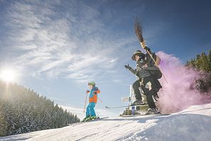 Hexe und Kind fahren Ski.