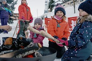 Kinder machen Stockbrot im Winter.