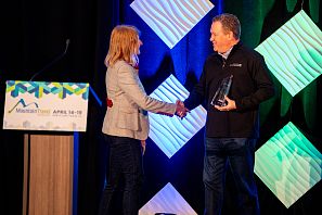 Anita Baumgartner Hände schüttelnd auf der Bühne bei Auszeichnungsverleihung des Internationalen Nachhaltgkeits-Awards 2024 in den USA Lake Tahoe