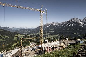Kran bei einer Baustelle mit Blick auf den Wilden Kaiser.