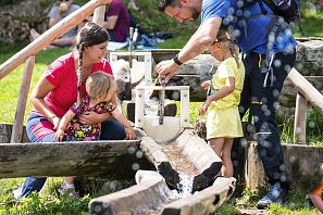 Familie spielt mit den Kindern am Wasser.