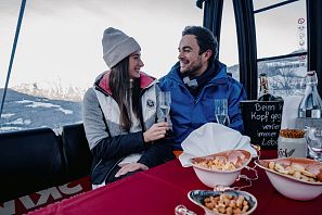 Pärchen bei einer Gondelfaht mit Sekt und Knabbereien.