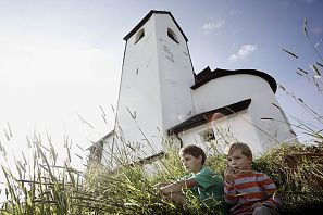 Kinder sitzen vor der Salvenkirche.
