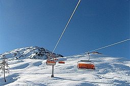 Siller Keat Sessellifte mit orangen Kuppeln mit Bergblick im Hintergrund.