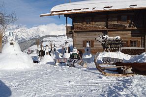 Schneemänner vor der Simonalm im Winter.