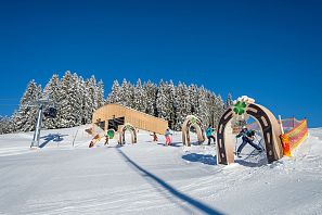 Kleine Skifahrer die im Hans im Glück Skiparkour das Skifahren spielerisch lernen.