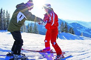Frau lehrnt das Skifahren von ihrem Skilehrer.