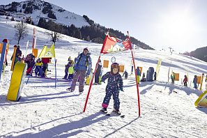 Kind fährt durch Hinderniss bei einem Skirennen.