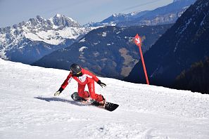 Eine Snowboarderin die einen Snowboard Kurs in der SkiWelt Westendorf macht.