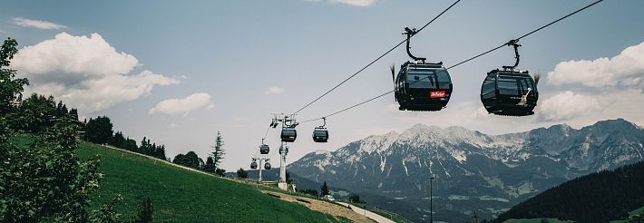 10er Gondel Salvenbahn fährt richung Hexenwasser. Schwarze Gondeln mit Blick auf den Wilden Kaiser