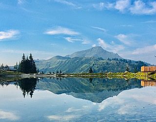 Ausblick auf einen Berg direkt am Ufer eines kristallklaren Sees.