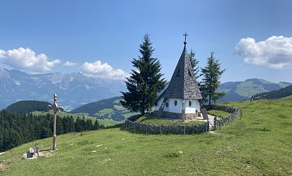 Kleine Kapelle und Kreuz auf einem Berg mit schönem Panorama.