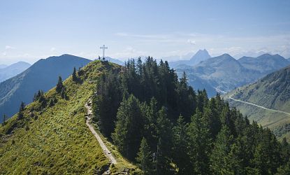 Ausblick auf das Gipfelkreuz und die umliegenden Berge.