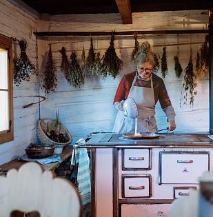 Oma kocht in einem alten Haus auf einem alten Ofen.