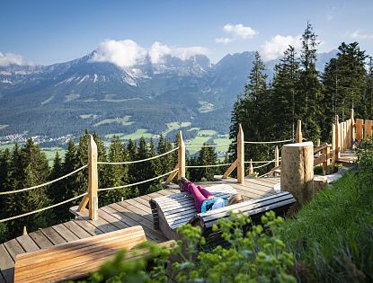 Holzliegen zum entspannen mit Ausblick auf die Berge.