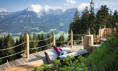 Holzliegen zum entspannen mit Ausblick auf die Berge.
