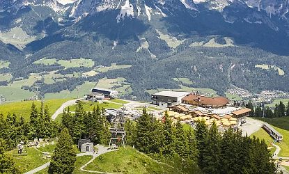 Luftaufnahme der Gipfelstation Hartkaiser in ellmau mit Bergrestaurant, Sessellift, Ellmis Zauberwelt und umliegender Alpenlandschaft.