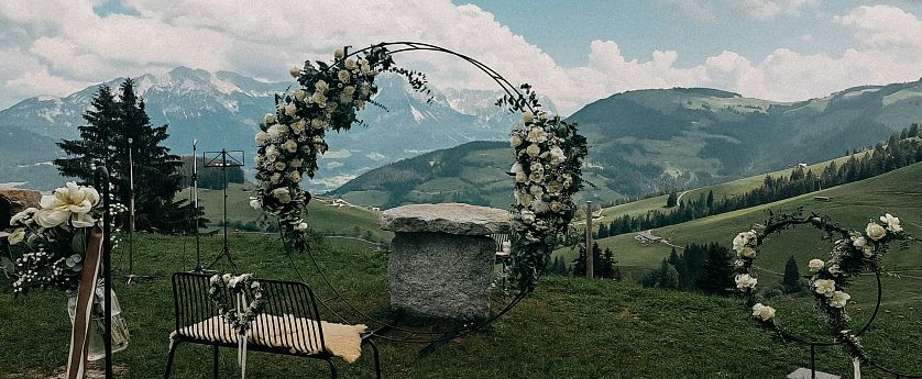 Hochzeitbogen mit weißen Blumen vor Panoramablick bei der Kraftalm SkiWelt Itter