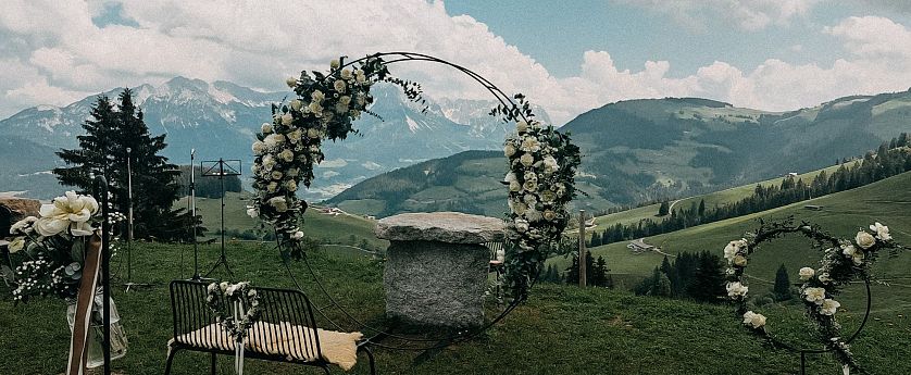 Hochzeitbogen mit weißen Blumen vor Panoramablick bei der Kraftalm SkiWelt Itter