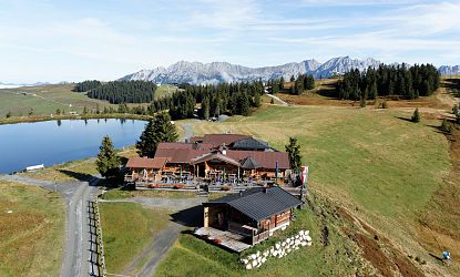Gasthaus am Berg neben einem Bergsee.