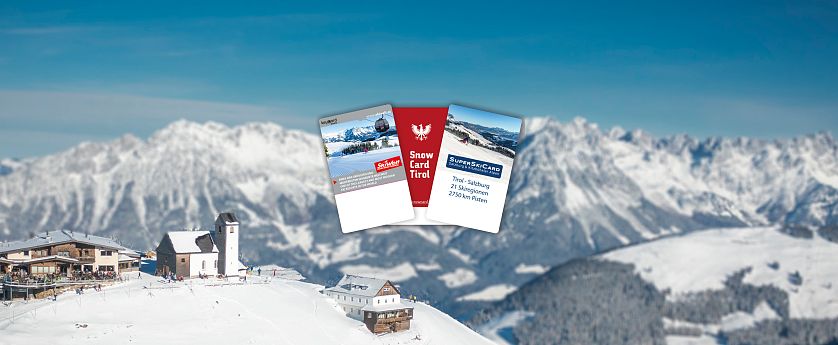 Skipässe (SkiWelt, Snow Card Tirol, SuperSkiCard) sind vor einem schneebedeckten Panorama und einer Berghütte mit Kapelle auf der Hohen Salve zu sehen