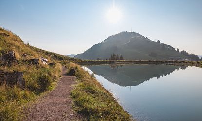 Wanderweg mit Blick auf einen See und die Hohe Salve.