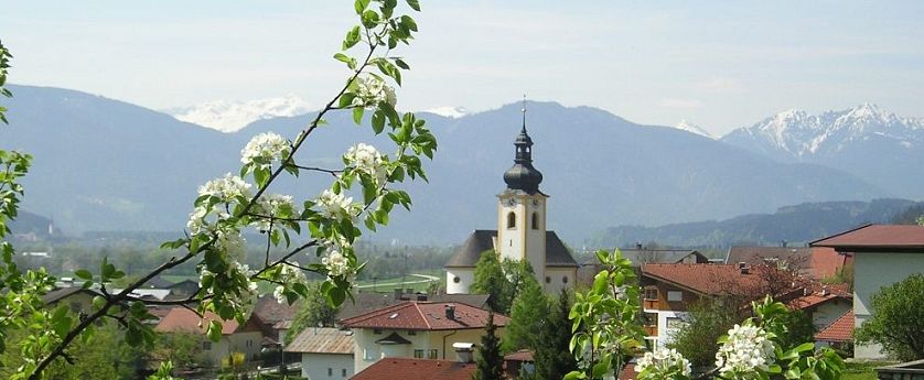 Ortschaft Langkampfen im Inntal bei Kufstein im Sommer, blühende Wiese und Kirche im Hintergrund