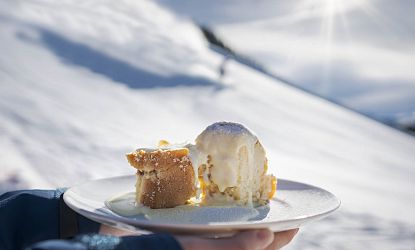 Mehlspeise vor einer Skipiste.