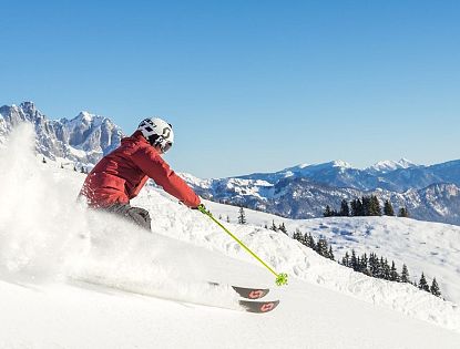 Skifahrer flitzt die Piste hinab in der SkiWelt Wilder Kaiser-Brixental.