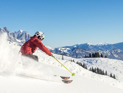 Skifahrer flitzt die Piste hinab in der SkiWelt Wilder Kaiser-Brixental.
