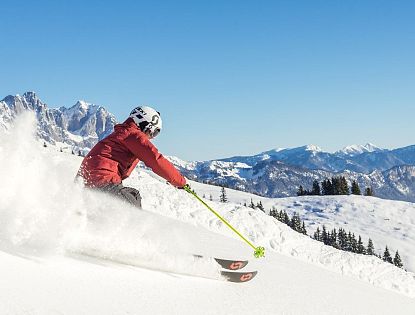 Skifahrer flitzt die Piste hinab in der SkiWelt Wilder Kaiser-Brixental.
