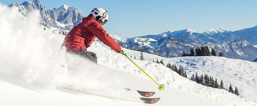 Skifahrer flitzt die Piste hinab in der SkiWelt Wilder Kaiser-Brixental.