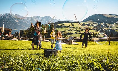 Hexen und Kinder stellen Riesenseifenblasen her.