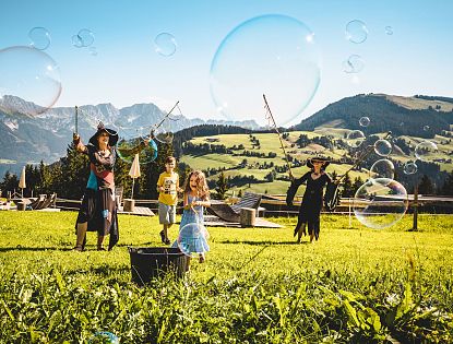Hexen und Kinder stellen Riesenseifenblasen her.