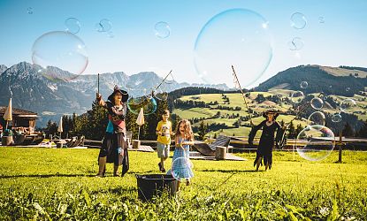 Hexen und Kinder stellen Riesenseifenblasen her.