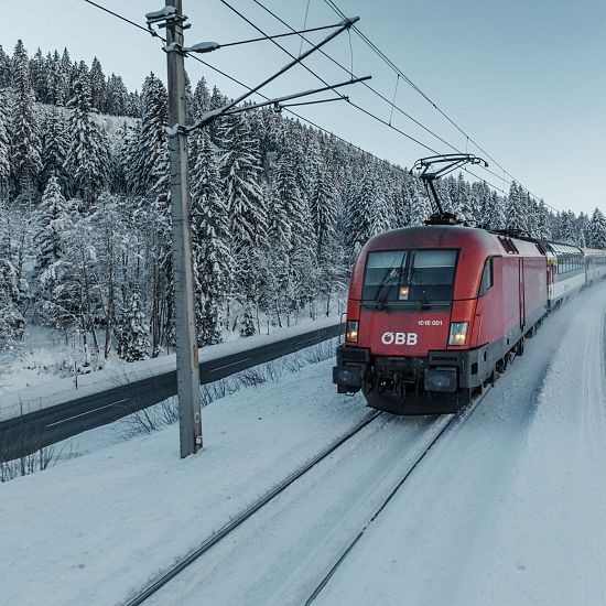 Zug fährt im Winter bei Schnee.