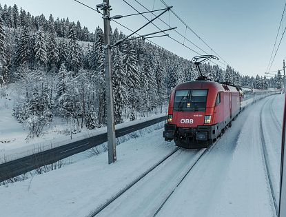Zug fährt im Winter bei Schnee.
