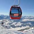 Rote Gondel schwebt über der Winterlandschaft.