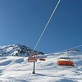 Siller Keat Sessellifte mit orangen Kuppeln mit Bergblick im Hintergrund.