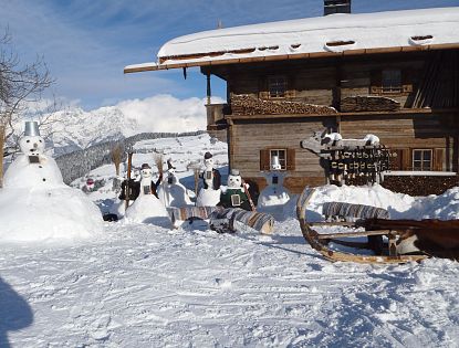 Schneemänner vor der Simonalm im Winter.