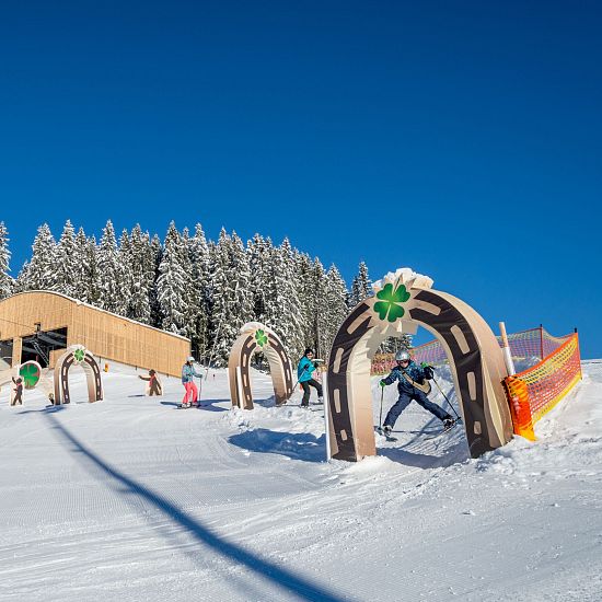 Kleine Skifahrer die im Hans im Glück Skiparkour das Skifahren spielerisch lernen.