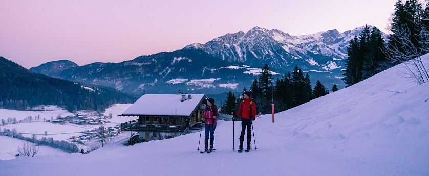 Freunde gehen bei Sonnenaufgang Skitouren.