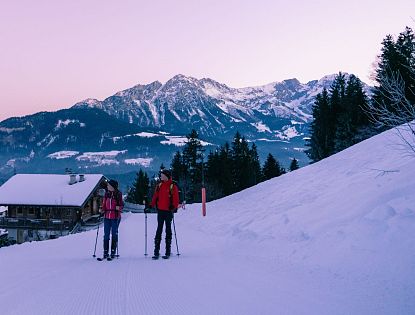 Freunde gehen bei Sonnenaufgang Skitouren.